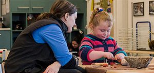 Image of an educator working with a young child in guided play